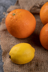 Orange and lemons on a burlap on the blue table. Top view.