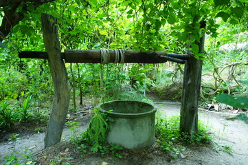 Fototapeta premium Wooden logs with rope on top of well for underground water