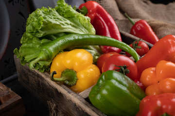 Bell peppers and lettuce ina wooden tray.