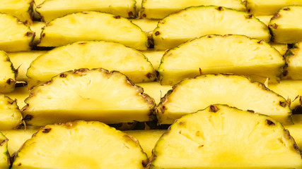 Pineapple juicy yellow slices background. Top view.
