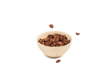 Chocolate corn flakes falling to the white bowl isolated on white. Motion.