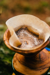 Coffee break with drip coffee on the forest, ground coffee on the filter paper and wood dripper