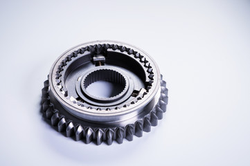 New parts on a gray background. Gears of gear shifting torque transmission. Conceptually mechanical background. Shiny gear box gear teeth