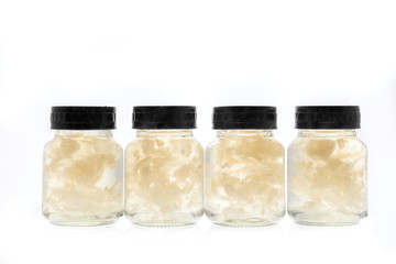 Bird nest packed in glass bottle packaging with black lid. Isolated on white background