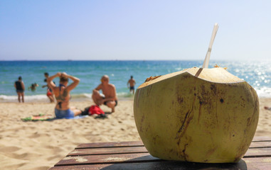 Coconut with straws on the sea beach