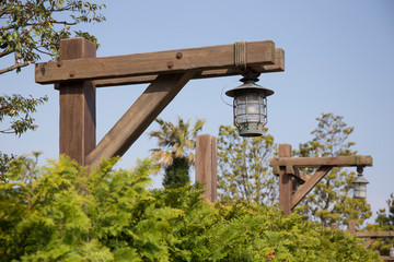 Lamps on street at harbor hanging from wooden poles in sunny day