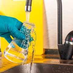 water purification specialist tap water pours into a glass flask.