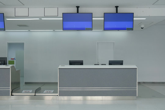 Airport check-in counter with monitor screens hanging