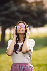 Woman With Headphones Outdoors in the City Park