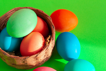 Vibrant colored eggs in a nest on green. Easter concept