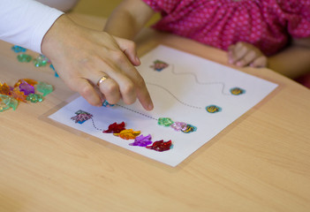 Child hands playing with the colorful stones to develop fine motor skills
