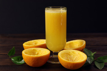 A glass of fresh orange juice on a wooden table. Healthy food.