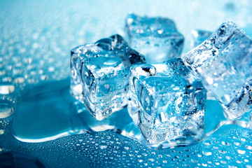 Obraz premium Kostki lodu / Teksturowane mroźne, krystalicznie czyste bloki lodu na białym tle na niebieskim tle.