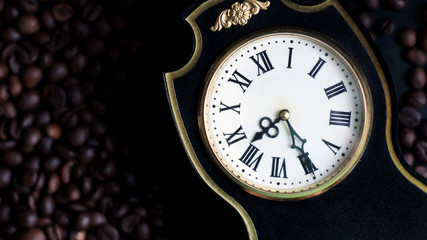 Antique black clock with Roman numerals and coffee beans