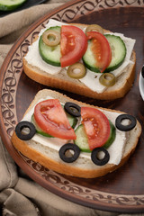 sandwiches with cheese, tomato, cucumber and black and green olives.