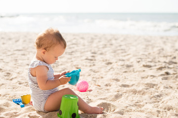 Baby playing on the sandy beach near the sea
