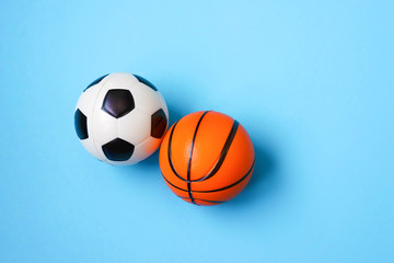 Miniature of a football and basketball on a blue background. Physical development of the child. Development center. How much does health cost?