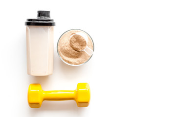 Sport nutrition. Whey protein, shaker, dumbbells on white background top-down flay lay copy space
