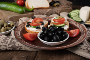 Black olives with sandwiches in a platter