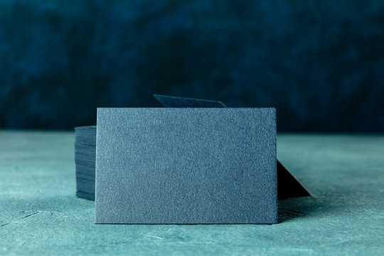 Business cards, a blank mock-up for a stack of dark blue thick cardboard cards on a dark backgroud with a place for text