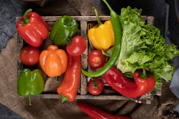 Chilies and lettuce in a wooden tray. Top view.