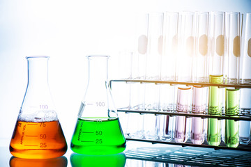 chemical liquid containing in flask with lab glassware on white background, lab research and...