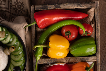 Colorful chilies and bell peppers in a wooden container