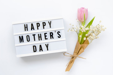 Lightbox with sign Happy Mother's Day and blossom bouquet isolated on white. Top view