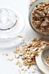 scattered oatmeal in a glass jar on a white background