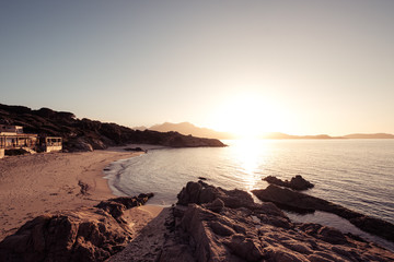 Sun setting over beach and calvi citadel in Corsica