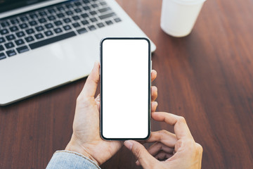 Mockup image blank white screen cell phone.man hand holding texting using mobile on desk at coffee shop.background empty space for advertise text.people contact marketing business,technology
