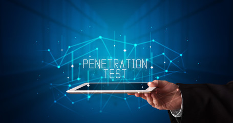 Young business person working on tablet and shows the digital sign: PENETRATION TEST