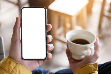 Mockup image blank white screen cell phone.man hand holding texting using mobile on desk at coffee shop.background empty space for advertise text.people contact marketing business,technology