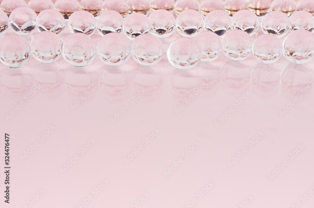Poster abstract elegant pink background with transparent round spheres with golden glitter inside in a row.