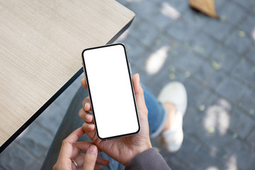 Mockup image blank white screen cell phone.woman hand holding texting using mobile on desk at coffee shop.background empty space for advertise text.people contact marketing business,technology