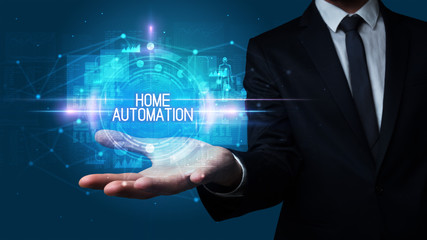 Man hand holding HOME AUTOMATION inscription, technology concept