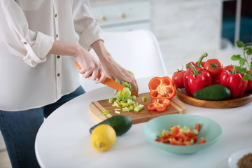 Obraz na płótnie Canvas Female hands slicing salad on a cutting board.