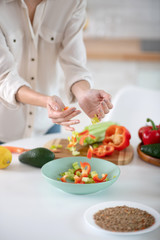 Obraz na płótnie Canvas Female hands pouring shredded vegetables into a plate.