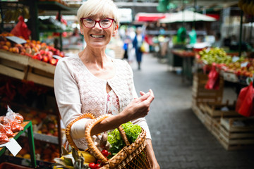 Mature woman buying vegetables at farmers market