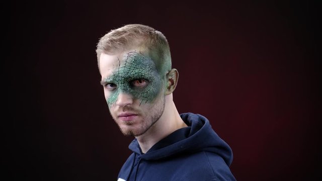 face of a man with green skin. terrible mutant character. make-up lizard man. a hero from a science fiction film. Halloween costume