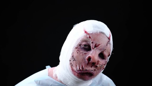visage of a patient with a disfigured face, a sewn-in mouth and a bandaged head. A hero from a horror movie or an costume for Halloween. Profassional make up