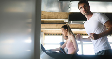 Group of people exercising in a gym cardio training and running