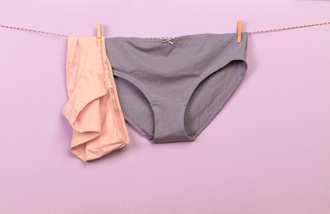 Female panties hanging on rope on pastel background - Image  - Image