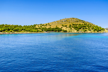 Adriatic coastline with rocky beach, island in the blue sea, Croatia, Dalmatia