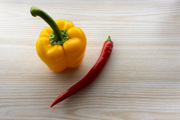 bell pepper and chili lie on a wooden table
