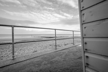  The view from the side of a traditional wooden beach hut on the Norfolk coast captured on a bright but cold winters day