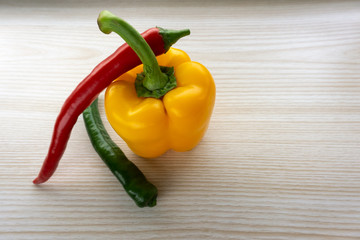 bell pepper and chili lie on a wooden table