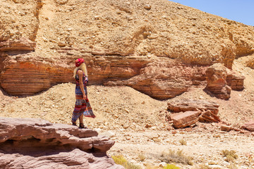 woman pose in rocky desert canyon landscape dry sand stone rocky warming nature environment space...