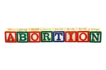 The word Abortion spelled in colorful wooden blocks, isolated on white background