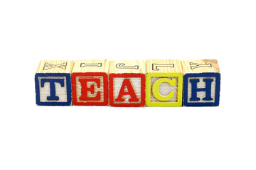 The word Teach spelled in colorful wooden blocks, isolated on white background